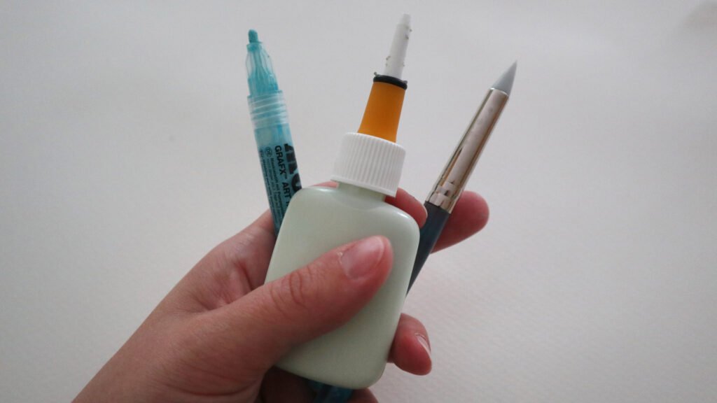 Maskiergummi fein auftragen zum Beispiel mit dem Molotow GRAFX Art Masking Liquid Pen, dem Masquepen aus Großbritannien oder Rubbelkrepp direkt mit einem Silikonpinsel.
