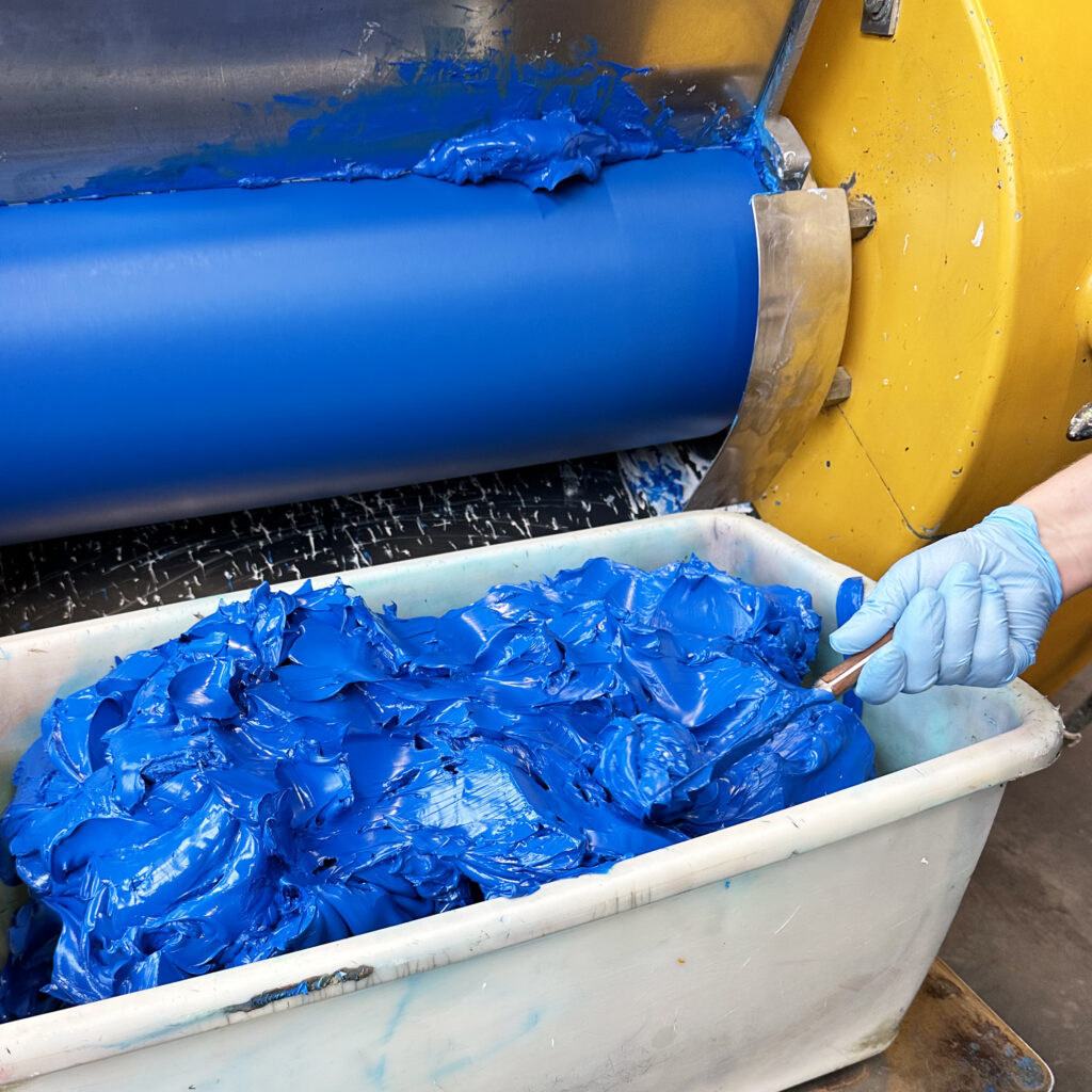 Ölfarbe wird bis zu vier mal durch gewalzt um Pigmente und Bindemittel einwandfrei zu vermischen.