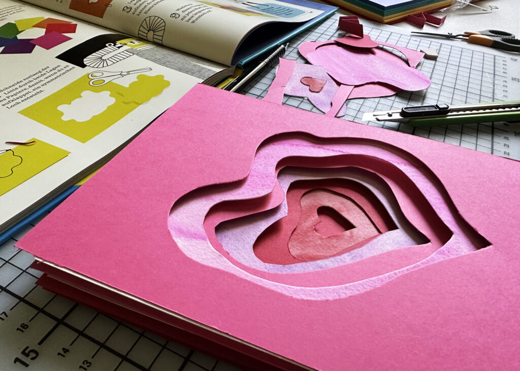 Die verschiedenen Lagen aus Papier mit abstandhaltenden Pappstreifen für den 3D-Effekt dazwischen.
