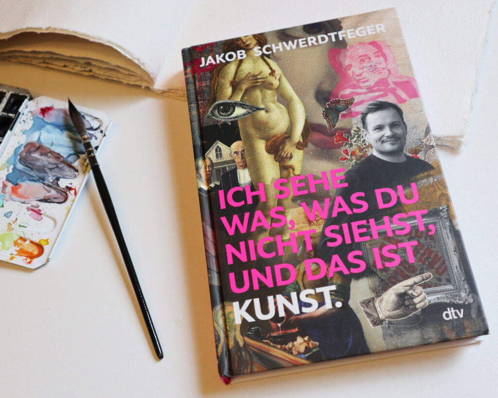 Der Spiegel-Bestseller "Ich sehe was, das Du nicht siehst, und das ist Kunst" von Jakob Schwertfeger neben meinen Aquarellfarben.