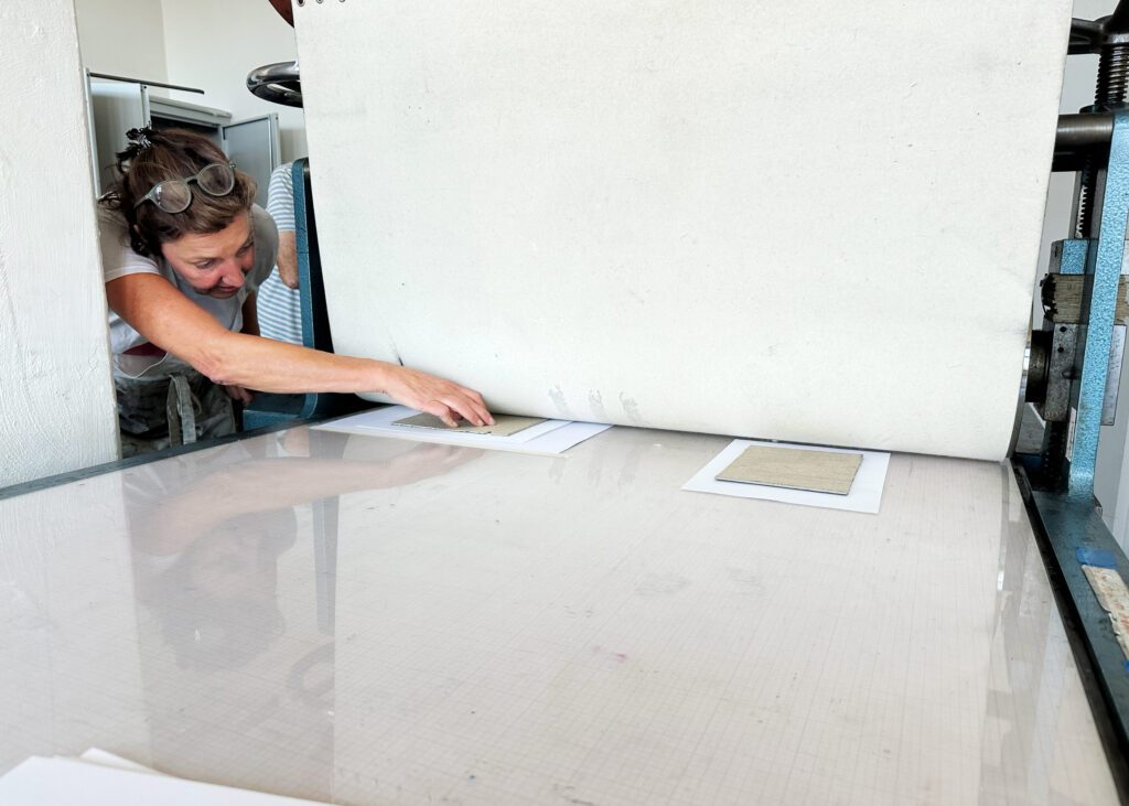 Die Druckplatte geht durch die Druckmaschine.