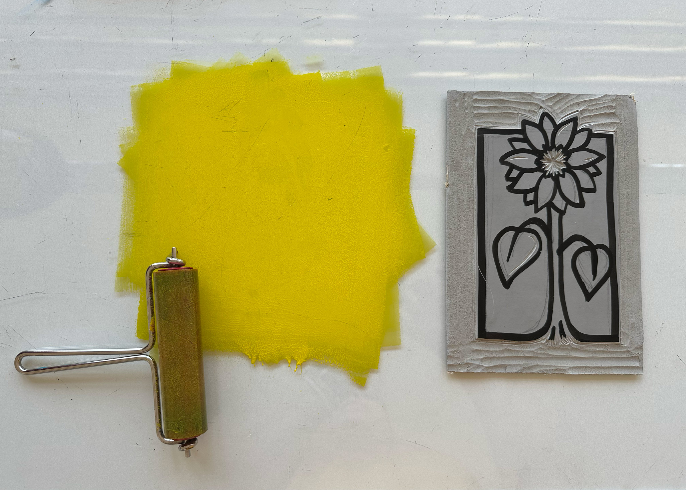 Die Linolplatte ist bereit für den ersten Farbauftrag mit gelber Farbe.