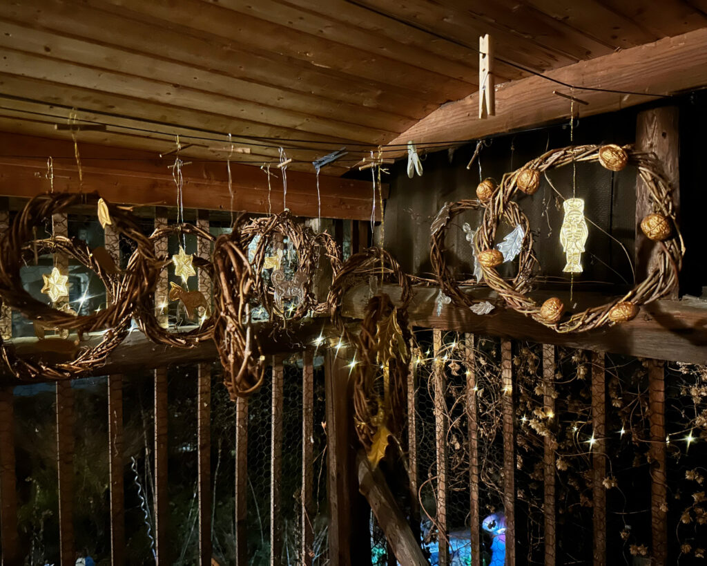 Die fertigen Deko-Kränze hängen im Dämmerlicht auf dem Schuppen.